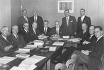 Thirteen men in a meeting room