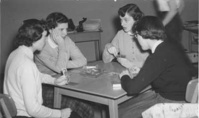 Women playing a card game in girls' common room, Waterloo College