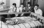 Waterloo College students gathered around a dormitory bed