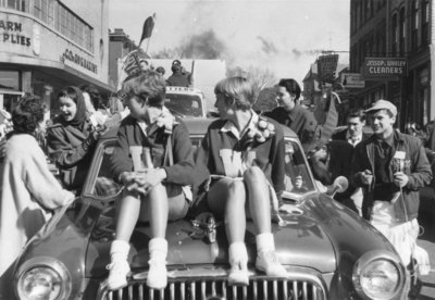 Waterloo College cheerleaders riding on a car in the 1955 Homecoming Parade