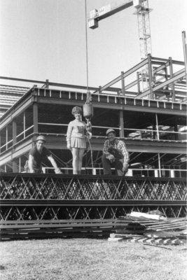 Waterloo Lutheran University cheerleader and construction workers on Central Teaching Building construction site