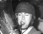 Waterloo Lutheran University student wearing a helmet and playing a tuba at the Canadian College Bowl, 1968