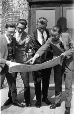 Four Waterloo College students reading a newspaper