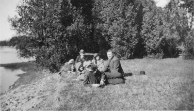 Seven people on a river bank