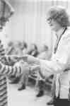 Flora Roy shaking hands with unidentified woman