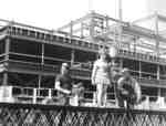 Waterloo Lutheran University cheerleader and construction workers on Central Teaching Building construction site