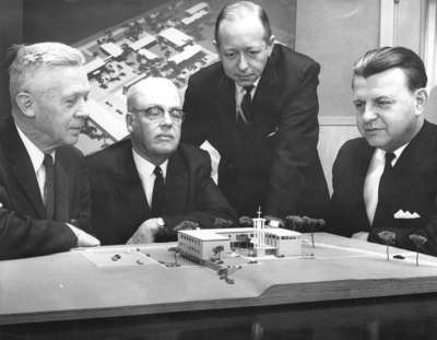 Four men looking at model of Waterloo Lutheran Seminary building