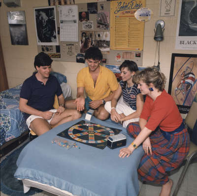 Four students playing board game in residence room, Wilfrid Laurier University