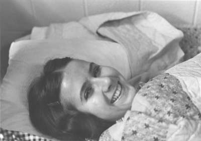 Woman laying in residence room bed, Waterloo Lutheran University