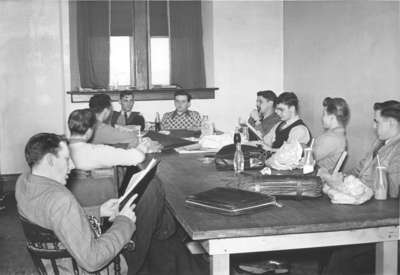 Nine male Waterloo College students seated at a table