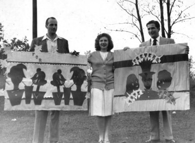 Three Waterloo College students holding banners