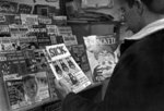 Man standing in front of magazine rack