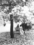 Two students sitting on a bench at Wilfrid Laurier University