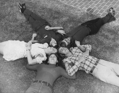 Wilfrid Laurier University students laying on grass