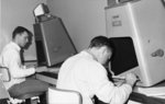 Two men using microfiche readers in the Waterloo Lutheran University Library