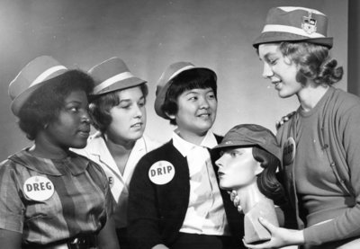 Four Waterloo Lutheran University students wearing hats and buttons