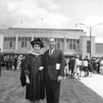Waterloo Lutheran University graduate and a man in front of the Kitchener Memorial Auditorium