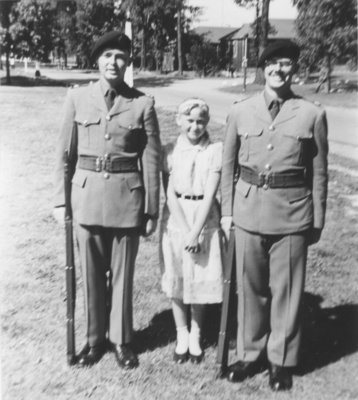 Two Canadian Officers' Training Corps cadets standing with a girl