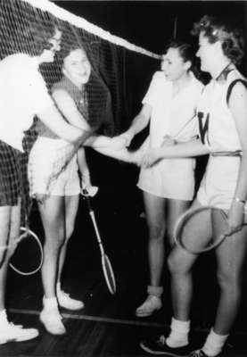 Four female badminton players shaking hands