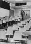 Man walking down stairs in empty lecture hall