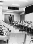 Man walking up stairs of empty lecture hall