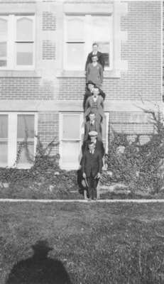 Seven men standing on a ladder