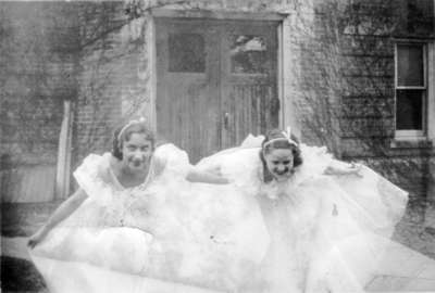 Two young women in formal gowns, in front of Willison Hall