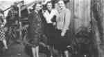 Three women standing in front of wooden bleachers