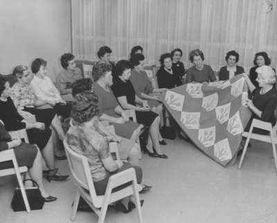 Women's Auxiliary members admiring a quilt