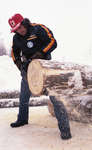 Homme coupant une bûche durant une compétition / Man Cutting Log in Competition