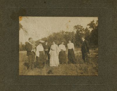 Group of Men and Women standing outside.