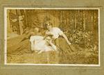 Man and two women lying in the grass