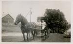 Two women riding a horse drawn carriage