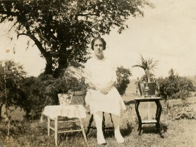 A young woman sitting on a stool outside