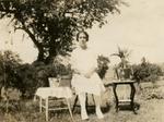 A young woman sitting on a stool outside