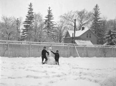 Two boys show off their snowman on the property of Harry Donald