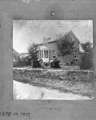 W.J. Luke, Veda Luke, Pearla Luke Alfred Luke and Mrs. W.J. Luke standing in front of the residence of W.J. Luke, c.1898