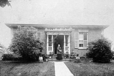 Gertrude Bryan in front of 206 Byron St. N., c.1910