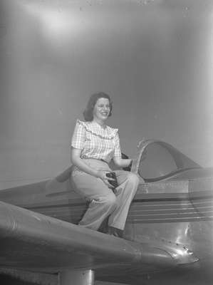 Unidentified woman sitting on a Ercoupe airplane, c.1940