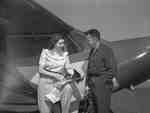 Unidentified woman and man next to Piper PA12 aircraft