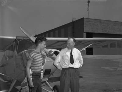 An unidentified man and flight student standing in front of Aeronca Champion