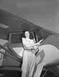 Unidentified woman standing in front of a Piper PA12 aircraft, c.1940