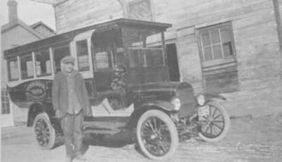 Man standing infront of Joseph Heard motor bus on Elm Street