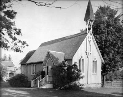 Rev. John C. Clough standing on the steps of St. Thomas Anglican Church