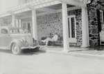 Unidentified man sitting outside the Arnold House