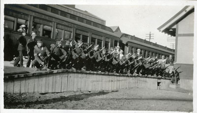 Soldiers kneeling on train station platform, holding weapons