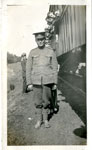 Photograph of a soldier standing beside a train