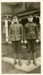 Photograph of 2 soldiers standing in front of a house