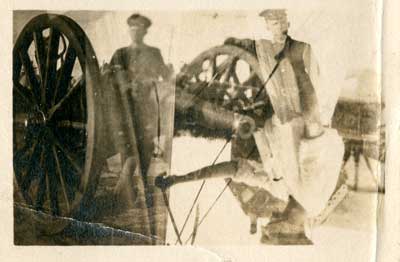 Two soldiers standing by a cannon, partially doubled exposed