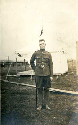 Photograph of soldier in dress uniform in front of a tent